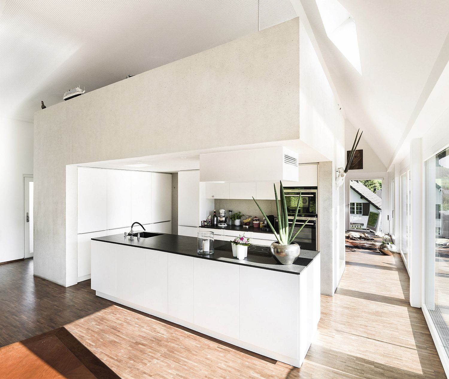 White concrete walls shape a modern, stylish kitchen