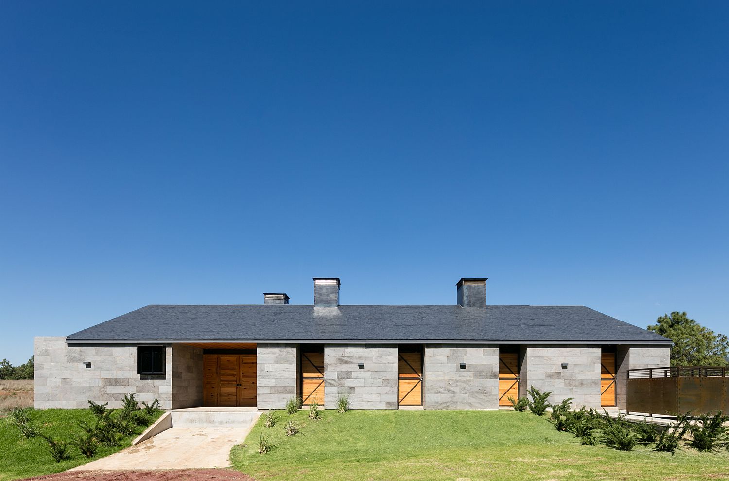 Modern Mexican ranch house with a gray exterior in volcanic rock
