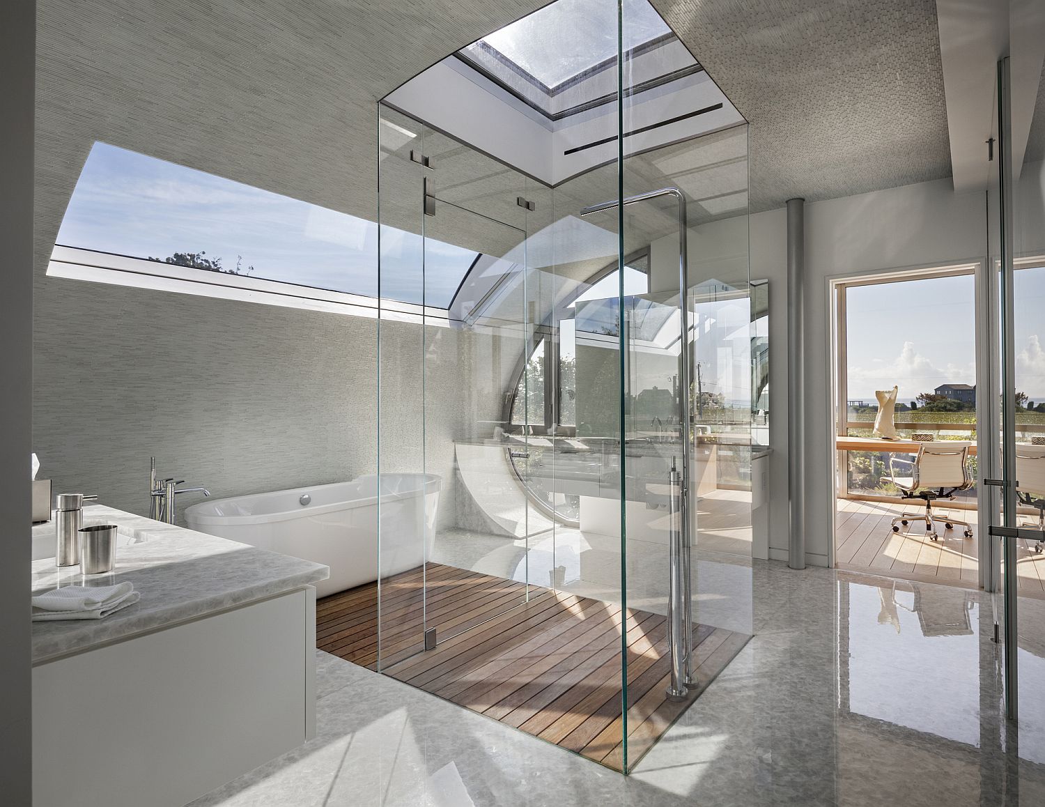 Lovely bathroom in white with an all-glass shower area and skylight