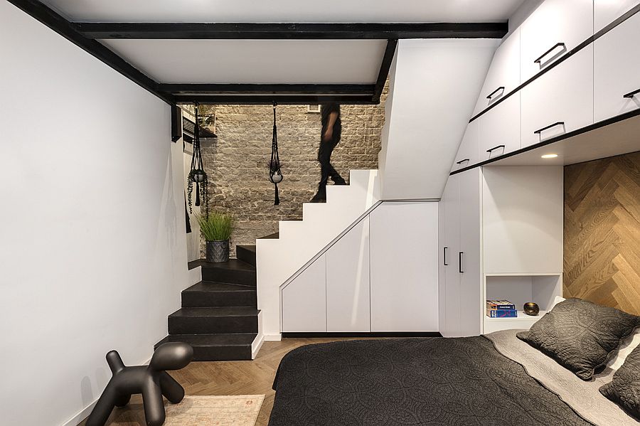 Storage cabinets in white with black lining are spread all across the bedroom