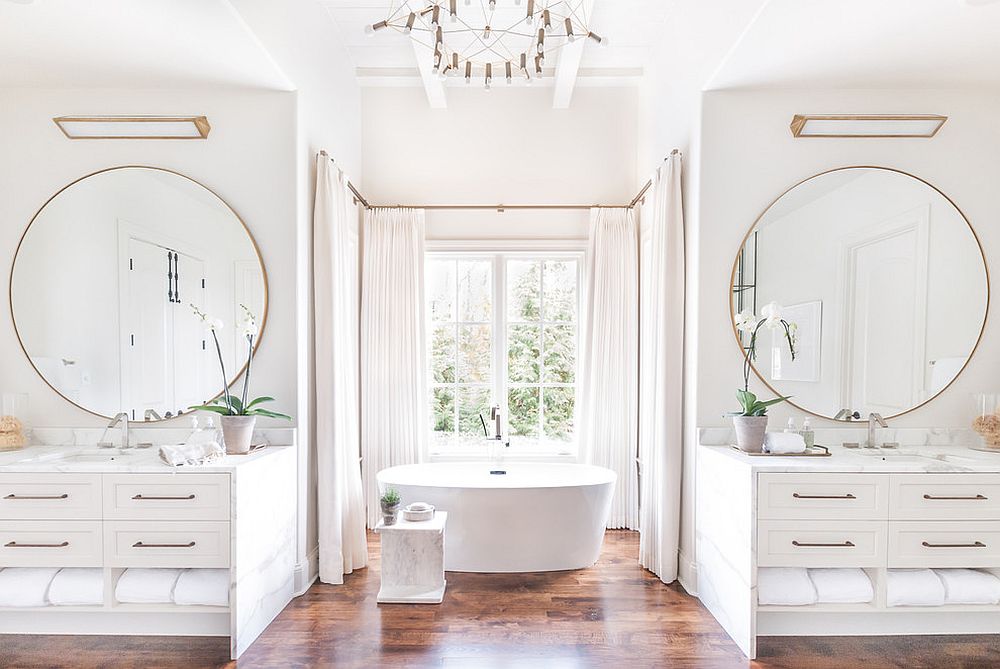 Gorgeous white bathroom with twin vanities, round mirrors and metallic accents