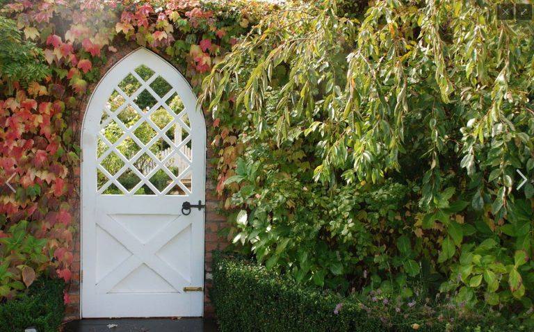 white door arch shape garden gate with trellis window