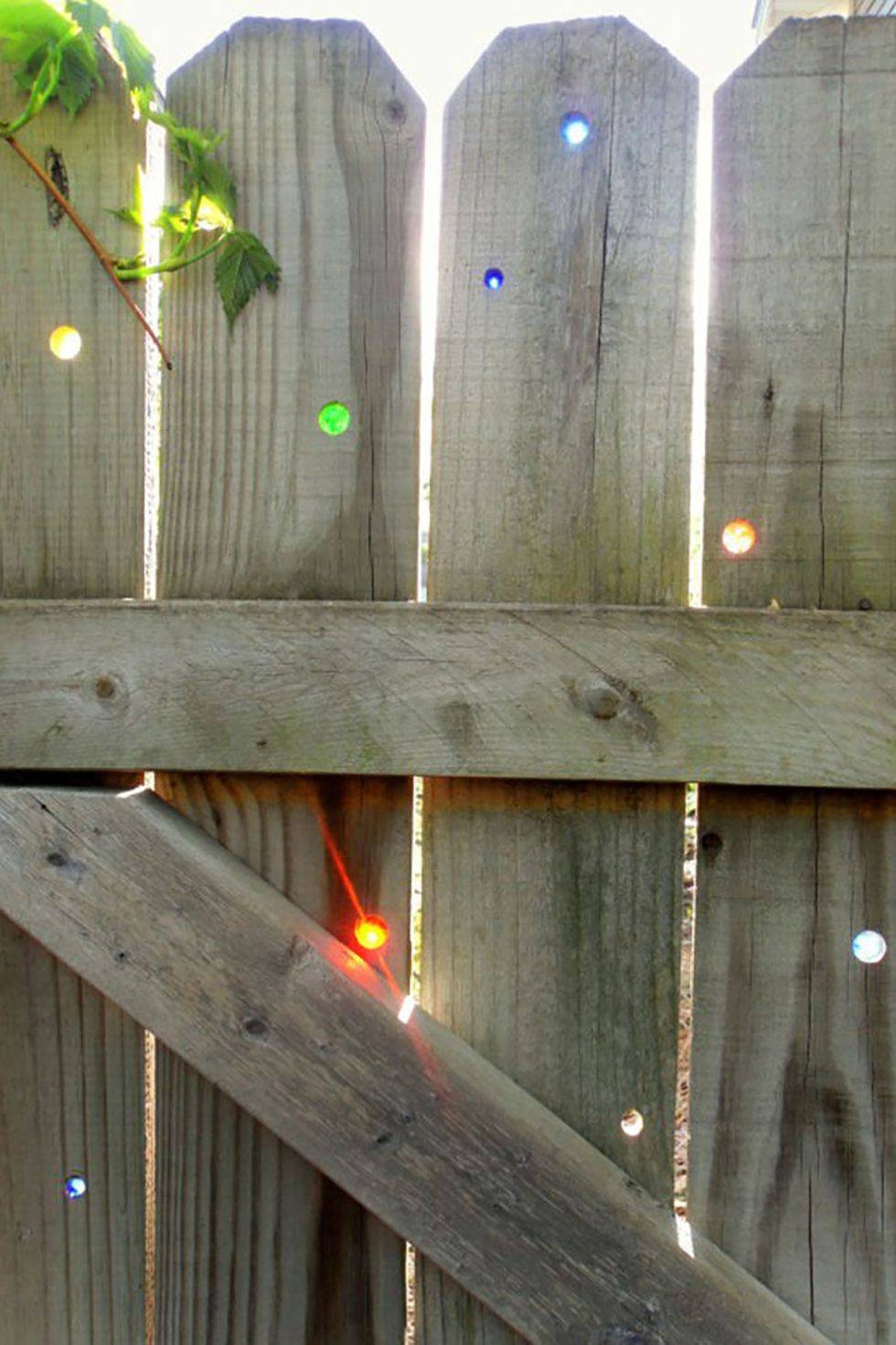 marble detailing in wooden garden gate with sun shining through